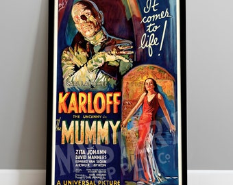 May include: A vintage film poster for the movie "The Mummy" starring Boris Karloff. The poster features a dark blue background with a large image of Karloff as the Mummy, with a woman in a red dress standing in front of a stone wall. The text "It comes to life!" is written in white at the top of the poster.