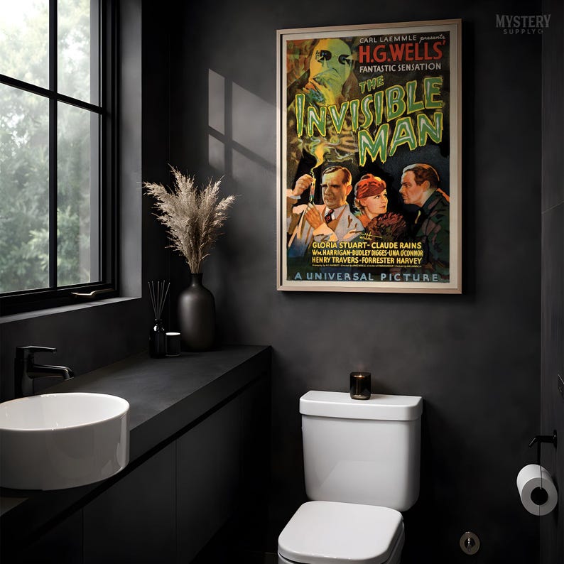 May include: A framed movie poster for The Invisible Man featuring a green-tinted ghostly figure above three people. The text reads Carl Laemmle presents H.G. Wells Fantastic Sensation The Invisible Man with Gloria Stuart, Claude Rains, and others.