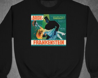 May include: Black sweatshirt with a vintage movie poster print of "The Bride of Frankenstein" featuring Boris Karloff. The poster has a green, orange, and red color scheme.
