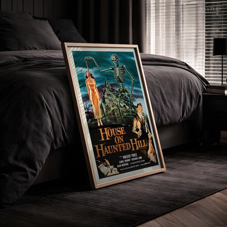 May include: A framed movie poster for House on Haunted Hill featuring a skeleton reaching toward a woman in a yellow dress, a man holding a candle, and a dark mansion. The text reads House on Haunted Hill, Vincent Price, Carol Ohmart, Richard Long.
