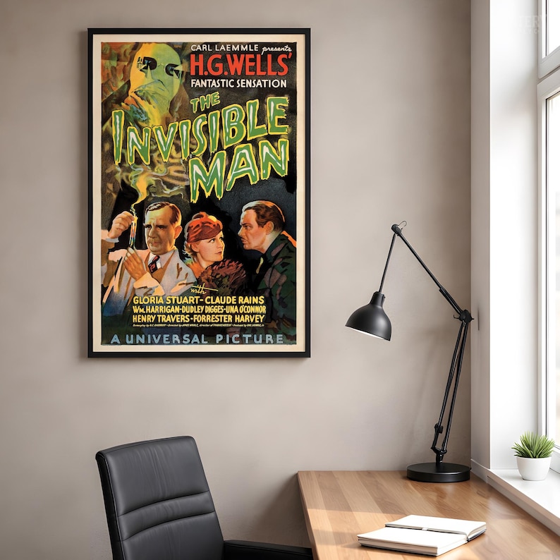 May include: A framed movie poster for The Invisible Man featuring a ghostly figure in goggles above three people. The text reads Carl Laemmle presents H.G. Wells' Fantastic Sensation The Invisible Man with Gloria Stuart, Claude Rains, and others.