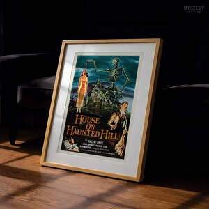 May include: A framed movie poster for House on Haunted Hill featuring a skeleton looming over a house, a woman in a yellow dress, and a man in a suit. The text reads House on Haunted Hill, Vincent Price, Carol Ohmart, Richard Long, Alan Marshal.