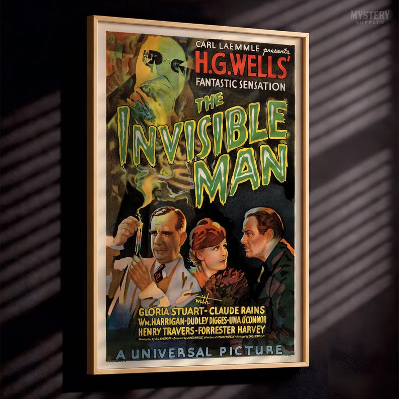 May include: A framed movie poster for The Invisible Man featuring a large, ghostly green face at the top and three people below. The text reads Carl Laemmle presents H.G. Wells' Fantastic Sensation The Invisible Man, A Universal Picture.