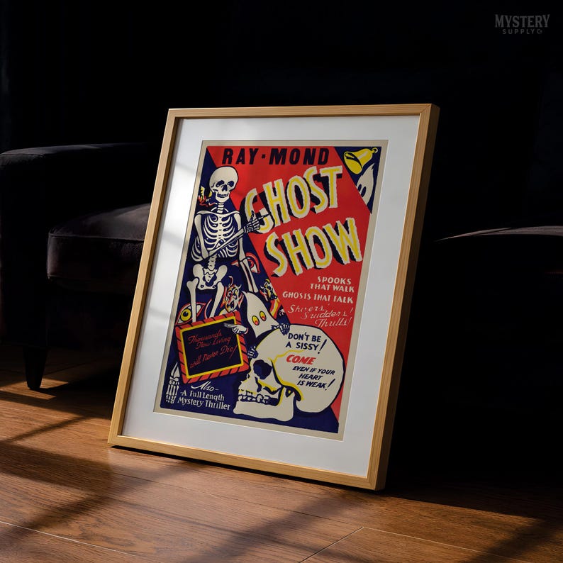 May include: A framed vintage-style poster titled Ghost Show by Ray-Mond, featuring a skeleton, a ghost, and a skull against a red and blue background. The text reads Spooks That Walk, Ghosts That Talk, Don't Be A Sissy, and Come Even If Your Heart Is Weak.