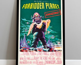 May include: A vintage movie poster for the science fiction film "Forbidden Planet" featuring a robot carrying a woman in a futuristic setting. The poster is in green, blue, and pink colors with the title "Forbidden Planet" in large white letters and the word "AMAZING!" in a red box.