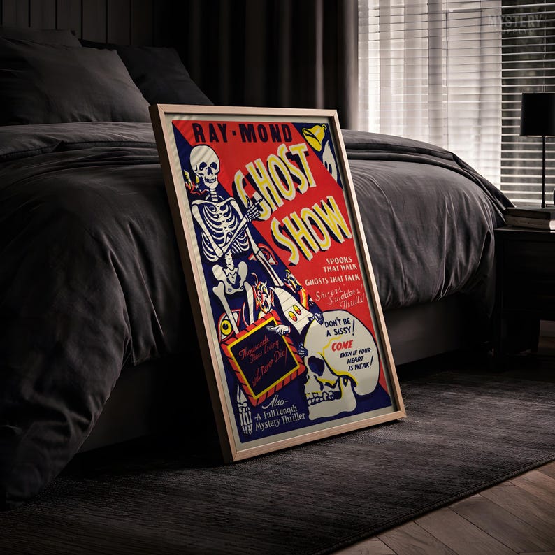 May include: A framed vintage-style poster titled GHOST SHOW featuring a skeleton illustration on a red and blue background. The text reads RAY-MOND, GHOST SHOW, SPOOKS THAT WALK, GHOSTS THAT TALK, DON'T BE A SISSY, COME EVEN IF YOUR HEART IS WEAK, and A Full Length Mystery Thriller.