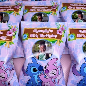 May include: Light purple party favor bags featuring Stitch and Angel characters. Each bag has a photo of a child and text that reads "Giselle's 6th Birthday". Floral and tropical leaf designs decorate the bags.