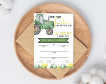 May include: A white fill-in invitation card featuring a green tractor illustration. Text reads "Start Your Tractor and Put It In Gear! 1st Birthday is Almost Here!" with spaces for date, time, place, and RSVP. The card is on a wooden plate.