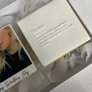 May include: A white square cookie with the word "Bestie" and its definition embossed on top. The cookie is in a white box with a photo and the text "Happy Galantines Day".