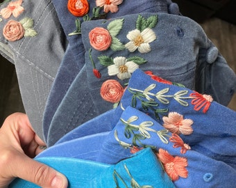 Hand embroidered floral distressed baseball hats in shades of blue and gray