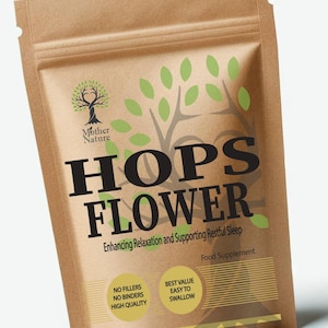 Può includere: Un sacchetto di carta marrone con un'etichetta che dice "HOPS FLOWER" in grandi lettere nere. L'etichetta dice anche "Enhancing Relaxation and Supporting Restful Sleep" e "Food Supplement". Ci sono due etichette più piccole che dicono "NO FILLERS NO BINDERS HIGH QUALITY" e "BEST VALUE EASY TO SWALLOW". Il sacchetto ha un disegno di albero verde con un cuore al centro.