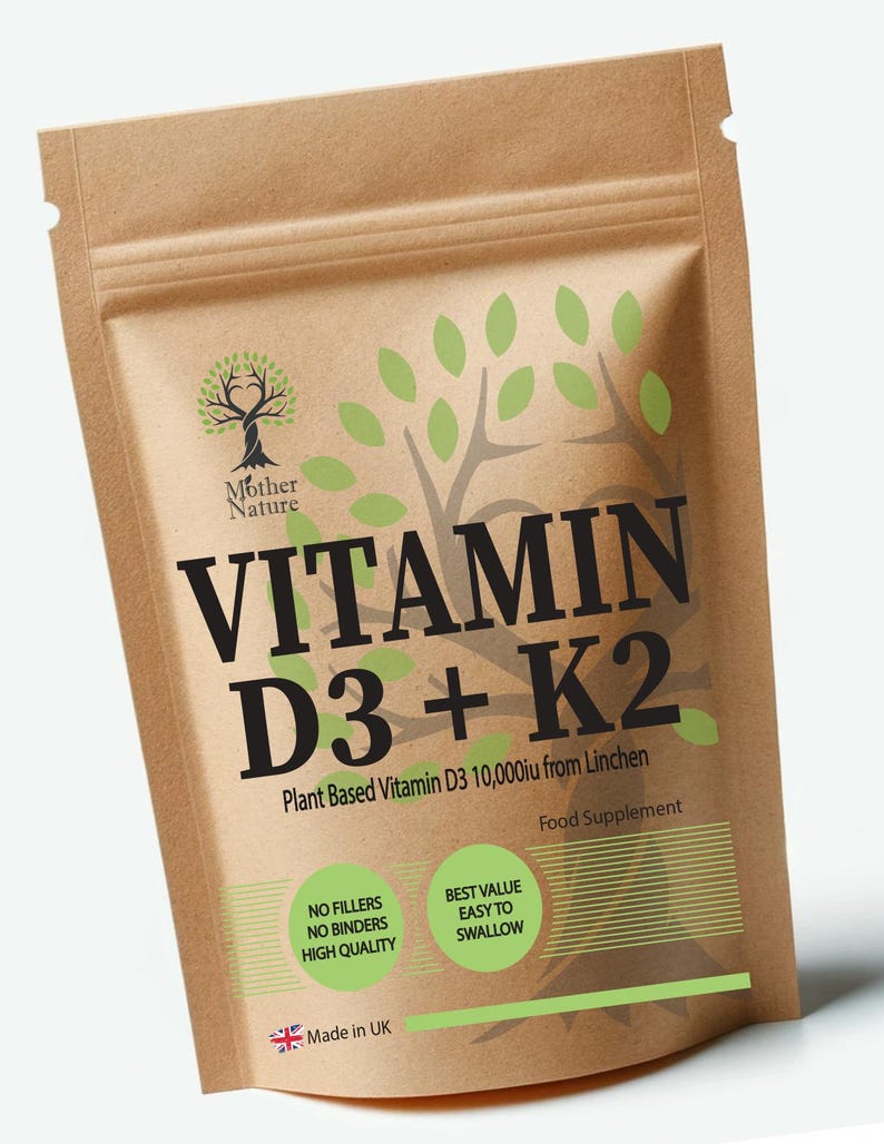 Op de afbeelding: Een bruine papieren zak met een wit label waarop "Vitamin D3 + K2 Plant Based Vitamin D3 10,000iu from Linchen" en "Food Supplement" staat. Het label heeft ook een groen boomlogo en de tekst "Mother Nature".