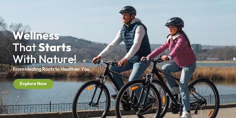 Puede incluir: Dos personas montan en bicicletas negras por un camino junto a un lago. Llevan cascos y ropa informal. La imagen incluye el texto "Wellness That Starts With Nature!" y el bot&oacute;n "Explore Now".