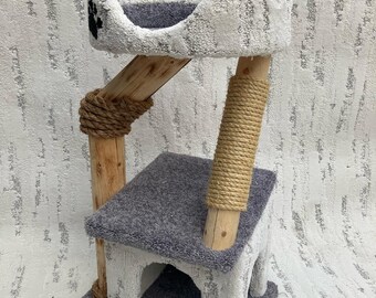 May include: A white cat tree with a gray platform, a gray bed, and a sisal-wrapped post. The cat tree has a small opening in the platform.