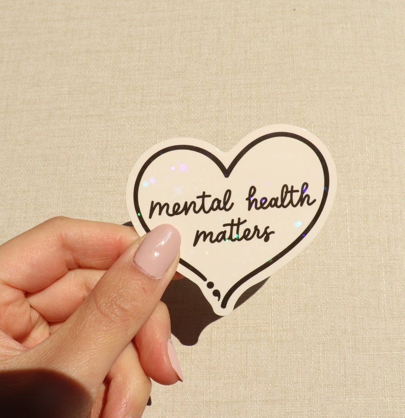 Pu&ograve; includere: Un adesivo bianco a forma di cuore con un contorno nero e il testo "mental health matters" in scrittura nera.