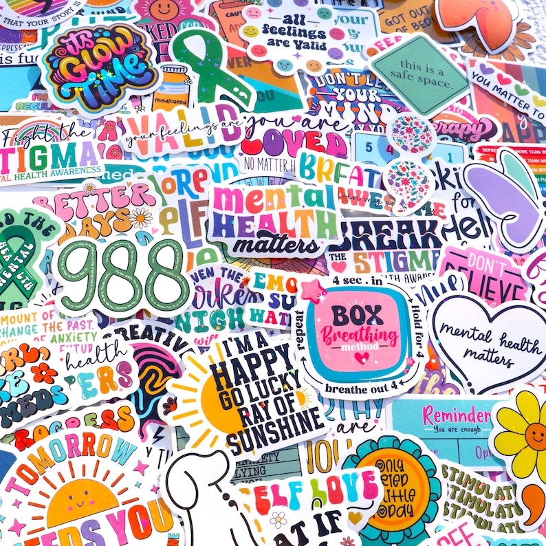 Pu&ograve; includere: Una collezione di adesivi colorati con messaggi positivi e temi di sensibilizzazione alla salute mentale. Gli adesivi presentano frasi come "Combatti lo stigma", "La salute mentale conta", "Giorni migliori", "Sono felice", "Raggio di sole fortunato", e "Amore per se stessi".