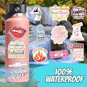 May include: A pink water bottle with various colorful stickers on it. The stickers feature book-themed designs with text such as "Escape Reality Read Books", "Emotionally Attached to Fictional Characters", "Spicy Book Club", and "Addicted to Spicy Books". The bottle is 100% waterproof.