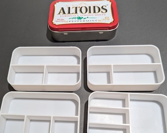 May include: Four white plastic rectangular boxes with dividers. The boxes are empty and have a smooth, glossy finish.