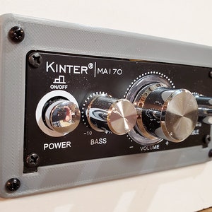 May include: A gray and black audio amplifier panel with the text "KINTER® MAI 70" and controls for power, bass, and volume.