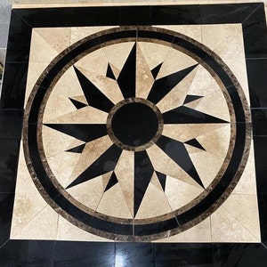 May include: A black and beige tile floor with a compass design. The compass is made of black and beige tiles and has a black center.