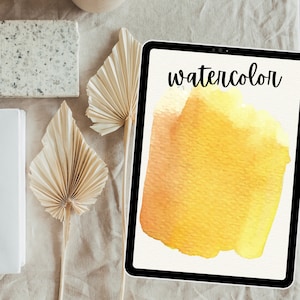 May include: A digital tablet displaying a yellow watercolor wash with the word "watercolor" in black text at the top of the screen.