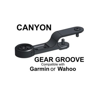 May include: A black Canyon Gear Groove mount featuring a circular interface for cycling computers. The text CANYON GEAR GROOVE Compatible with Garmin or Wahoo is displayed. The mount includes two vertical attachment points and a flat mounting arm.