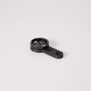 May include: Black bicycle computer mount with a circular top and an extended arm. The mount has two small screws and a hole at the end of the arm. The product is designed to hold a bicycle computer.