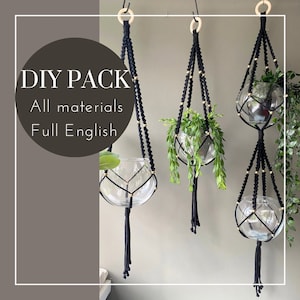 May include: Three black macrame plant hangers with gold beads and glass globes. The text "DIY PACK All materials Full English" is visible in the image.