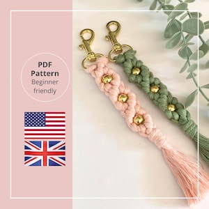 Pode incluir: Dois chaveiros de macramé, um rosa e outro verde, com ferragens e detalhes dourados. O chaveiro rosa tem uma borla. A imagem inclui o texto "PDF Pattern Beginner friendly" e as bandeiras americana e britânica.