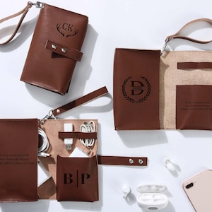 Könnte beinhalten: Drei braune Leder-Tech-Organizer mit Handschlaufen. Einer ist geschlossen, zwei sind geöffnet. Sie zeigen eingravierte Monogramme wie CK, DAVID und BP sowie den Text "Every moment with you feels like home. Happy anniversary, my love." Innentaschen enthalten weiße Ladekabel und Adapter.