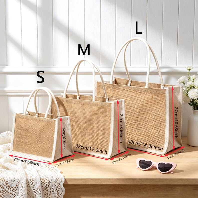 Puede incluir: Tres bolsos de yute rectangulares en tama&ntilde;os peque&ntilde;o, mediano y grande con bordes y asas blancas. El bolso peque&ntilde;o mide 22 cm de ancho por 16 cm de alto, el mediano 32 cm por 22 cm, y el grande 38 cm por 27 cm.