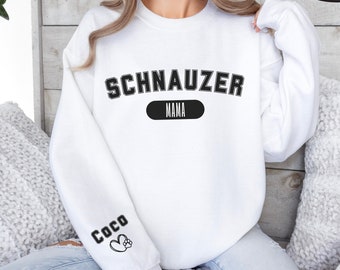 May include: White sweatshirt with the text "SCHNAUZER MAMA" in black lettering on the front and "COCO" with a paw print on the left sleeve.