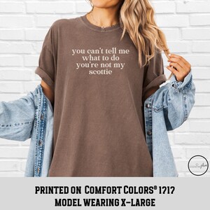Puede incluir: Una camiseta marr&oacute;n con el texto "you can't tell me what to do you're not my scottie" en blanco. La camiseta se lleva con una chaqueta vaquera. El texto "PRINTED ON COMFORT COLORS&reg; 1212" est&aacute; en la parte inferior.
