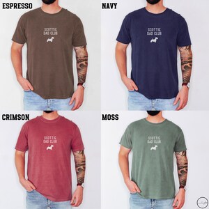 May include: Four t-shirts in different colors: espresso, navy, crimson, and moss. Each shirt has the text "SCOTTIE DAD CLUB" and a small white dog graphic. The shirts are short-sleeved and appear to be made of a soft material.