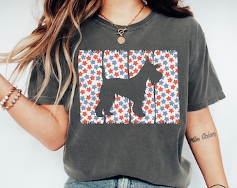 May include: Dark grey t-shirt with a black dog silhouette on a background of red, white, and blue stars. The design evokes the American flag. The shirt is a comfortable, casual style.