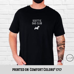 May include: Black t-shirt with the text "SCOTTIE DAD CLUB" and a white silhouette of a Scottish Terrier dog. The shirt is printed on Comfort Colors 1717.