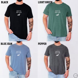 May include: Four t-shirts in black, light green, blue jean, and pepper colors. Each shirt has the text "SCOTTIE DAD CLUB" and a small white dog graphic. The shirts are short-sleeved.