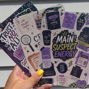 May include: Three rectangular sticker sheets featuring a dark, mystery-themed aesthetic with holographic glitter accents. The designs include text like 'Main Suspect Energy', 'Trust No One', and 'Evidence', alongside illustrations of typewriters, magnifying glasses, coffee cups, and books in shades of purple, black, and cream.