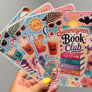 May include: A rectangular sticker featuring the text Summerween Book Club with illustrations of a jack-o'-lantern drink, a stack of books titled Beach Reads & Boo Vibes, Spooky Sunsets, Ghost Stories & Good Times, and Haunted Happy Hours, a bat, and a sun.