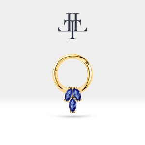 May include: A gold hoop earring with a dangling cluster of three marquise-shaped blue gemstones.