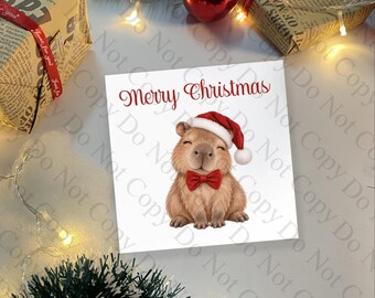 Pode incluir: Um cartão de felicitações quadrado com a ilustração de uma capivara castanha a usar um gorro de Pai Natal vermelho e uma gravata borboleta vermelha. O texto Merry Christmas está impresso em vermelho sobre a capivara num fundo festivo.