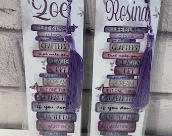 May include: Two rectangular bookmarks in clear plastic sleeves, each featuring a purple tassel. The designs show a stack of books with the names Zoe and Rosina at the top, followed by the text: Life is like a book, you will have chapters that make you laugh, cry, or just want to scream, but one thing is guaranteed, if you don't turn the page you won't know what the next chapter will hold for you.