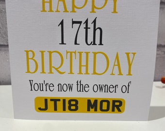 Pode incluir: Um cartão de felicitações quadrado branco com uma superfície texturizada. O texto diz HAPPY 17th BIRTHDAY em amarelo e preto, seguido de You're now the owner of em preto, e um gráfico retangular amarelo com o texto preto JT18 MOR.
