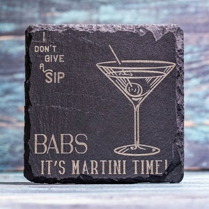 Puede incluir: Posavasos cuadrado de pizarra negra con diseño de copa de martini grabado y la frase "I don't give a sip, Babs, it's martini time!". El posavasos tiene un borde rugoso y es para bar.