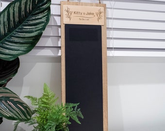 May include: A wooden to-do list board with a black chalkboard surface. The board has a wooden frame and a small wooden sign at the top that says "Kitty & Jake To Do List".