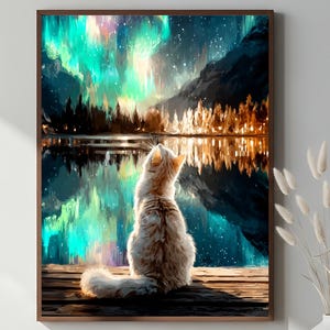 May include: A framed art print depicts a fluffy white cat gazing at a vibrant aurora borealis reflected in a lake. The scene includes mountains, trees, and a wooden dock, with a color palette of teal, orange, and brown.