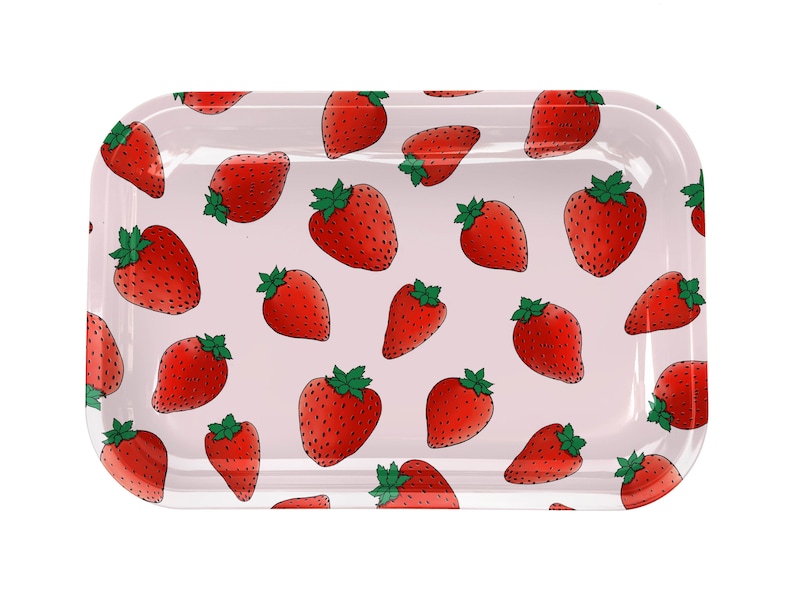 Puede incluir: Una bandeja rectangular rosa con un patr&oacute;n repetido de fresas rojas. La bandeja es de metal y tiene un acabado brillante.