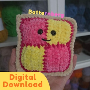 Puede incluir: Un juguete de peluche de ganchillo cuadrado con un patrón de tablero de ajedrez de cuadrados de lana rosa brillante y amarillo. El peluche tiene un borde beige, dos ojos de plástico negro y una sonrisa negra cosida. El texto Batternberg y Digital Download son visibles.