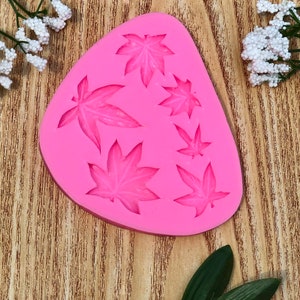 May include: Pink silicone mold with seven leaf shapes, perfect for making fondant or gum paste decorations.