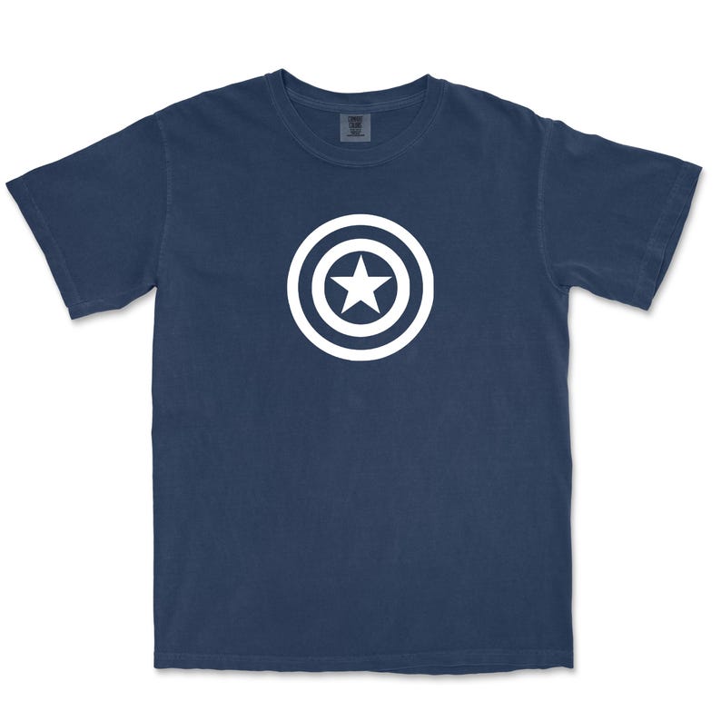 Puede incluir: Camiseta azul marino con un dise&ntilde;o blanco de una estrella dentro de un c&iacute;rculo. El dise&ntilde;o est&aacute; centrado en la parte delantera de la camiseta. La camiseta tiene mangas cortas y cuello redondo.